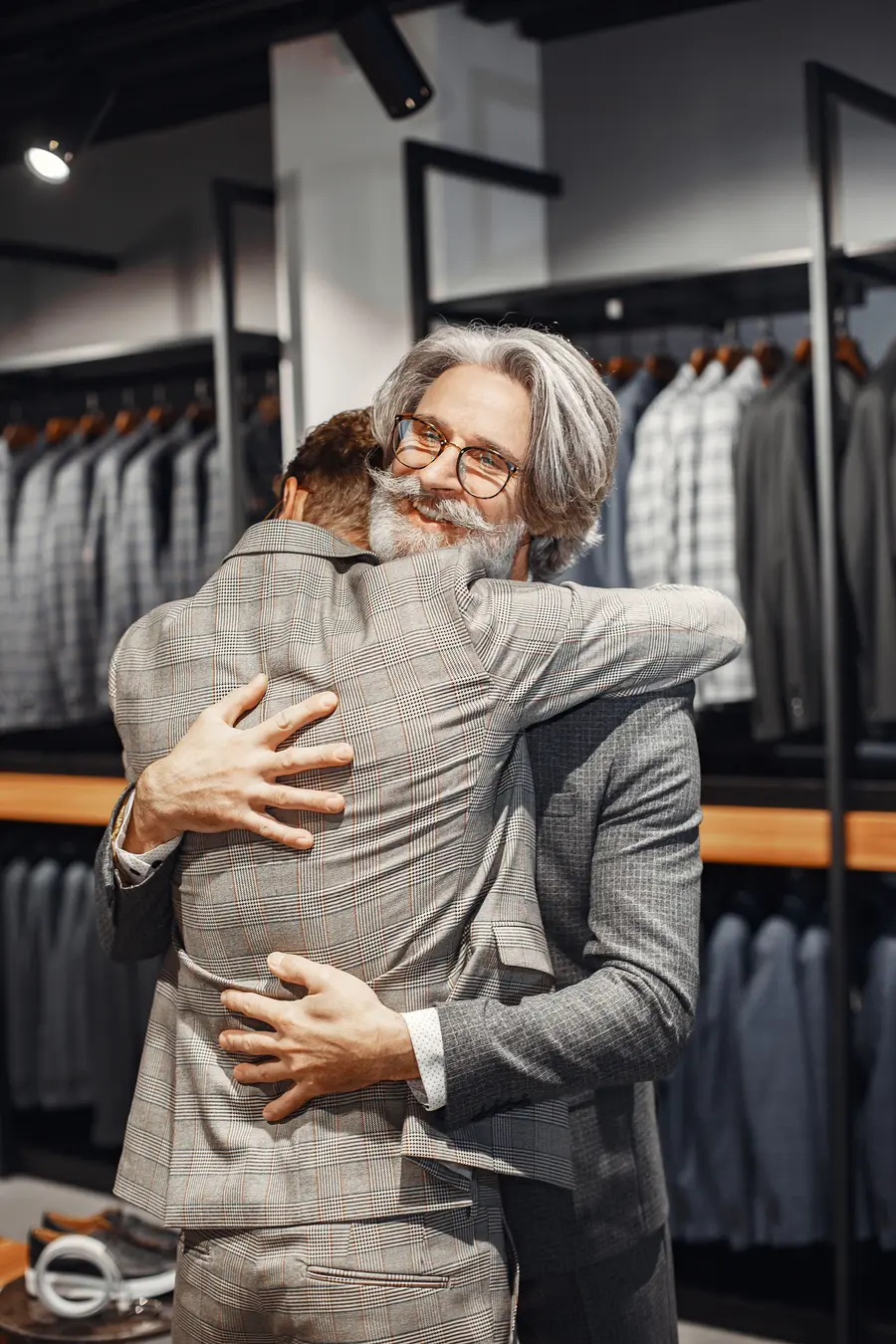 Customer hugging the tailor in a menswear boutique